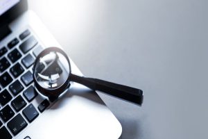 une loupe posée sur le clavier d'un ordinateur portable