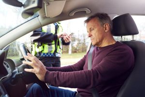 un homme arrêté par un policier au volant de sa voiture pour contravention
