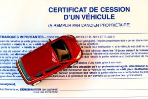 auto miniature posée sur un certificat de cession d'un véhicule